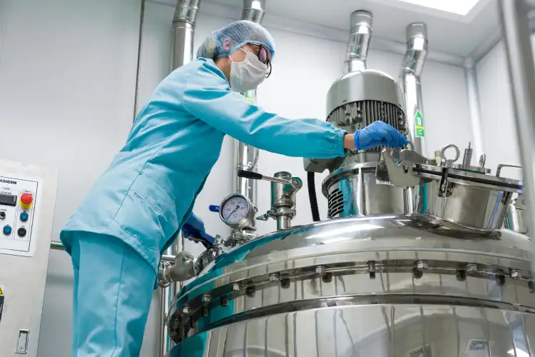 Food production worker in protective gear on a processing line